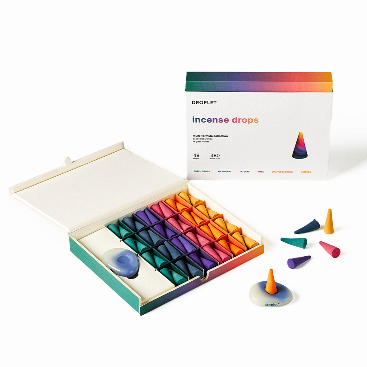 Droplet Incense Drops set with an open box showing colorful pyramid-shaped incense cones, a closed box in the background, and a few loose cones and a crystal ball on a white studio background.