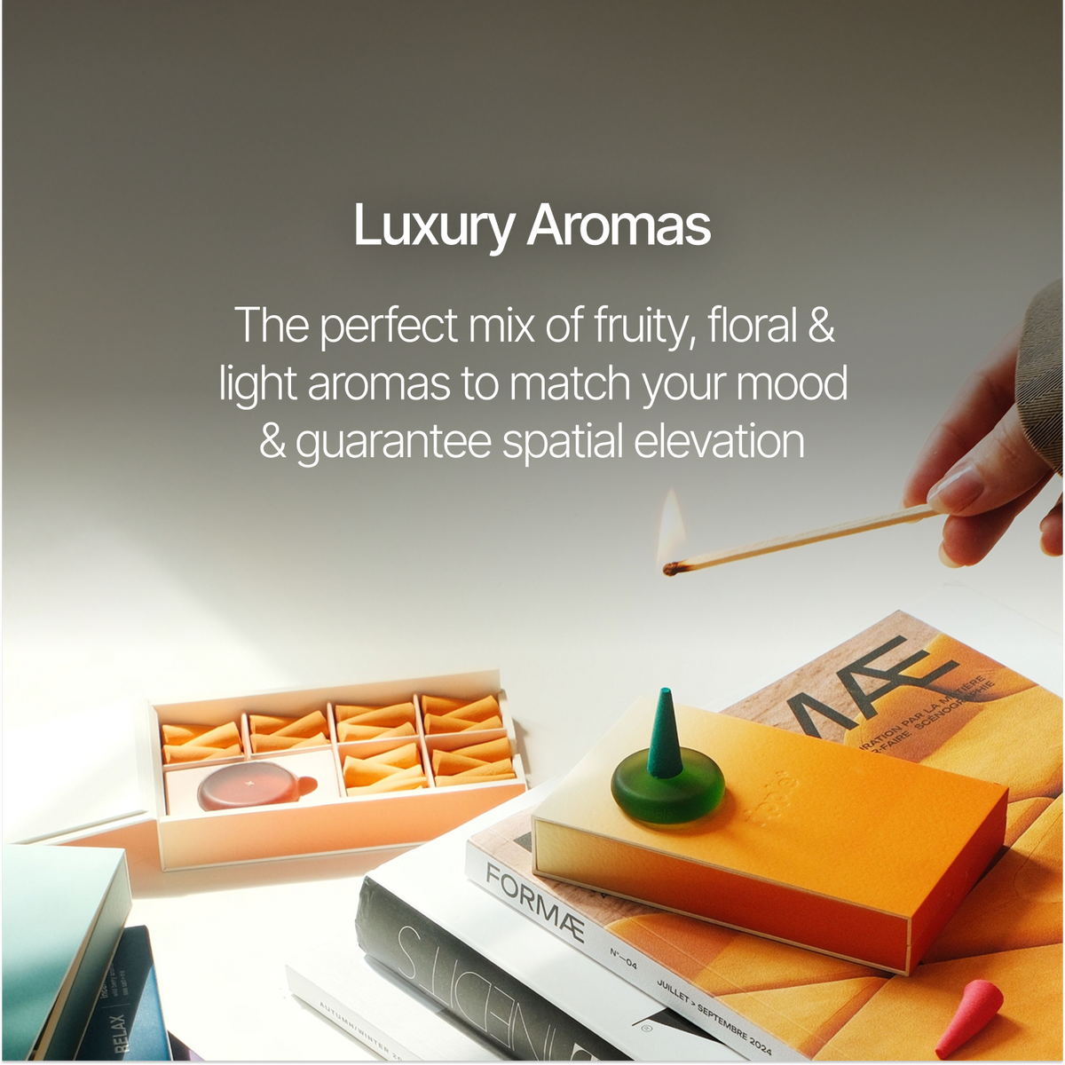 Luxury matchbox set with a lit match, books, and small orange matchsticks under the heading 'Luxury Aromas'.