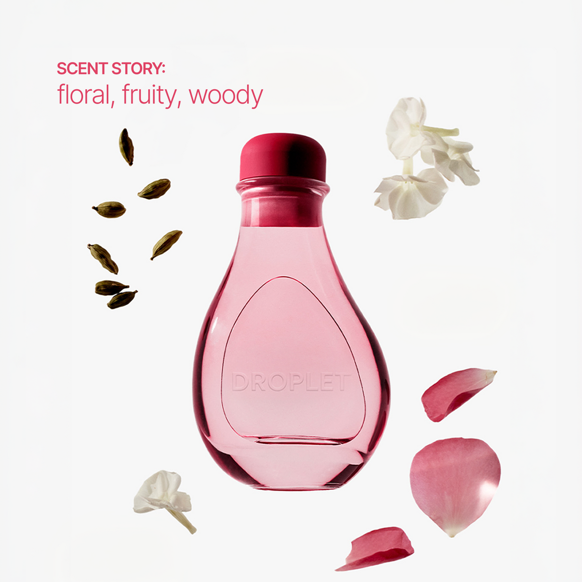 A pink glass dropper bottle with a dark pink cap, centered on a white background with scattered flower petals, white blossoms, and green seed pods. Pink text in the upper left reads 'SCENT STORY: floral, fruity, woody'.