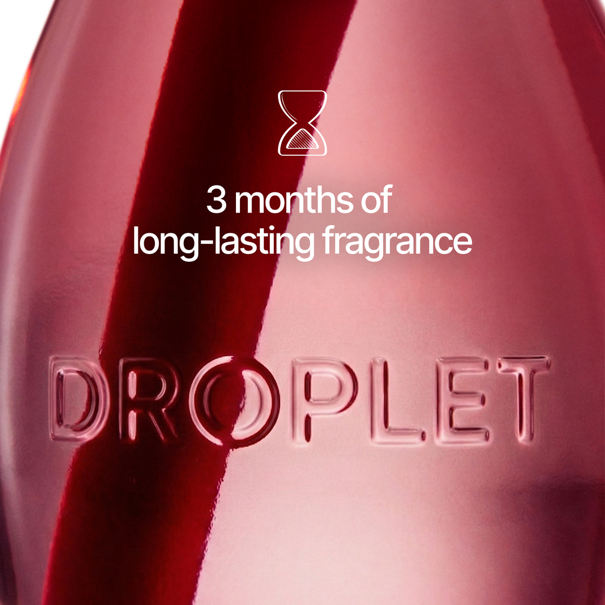 A close-up of a translucent deep pink fragrance bottle with the embossed brand name DROPLET and white text reading '3 months of long-lasting fragrance' with an hourglass icon.