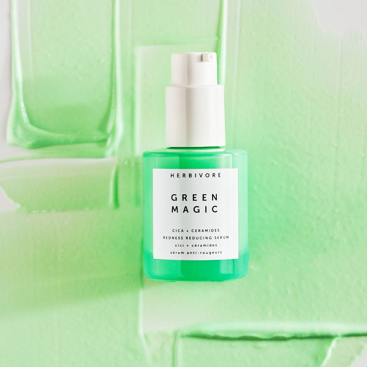 Bottle of Herbivore Green Magic serum on a green background