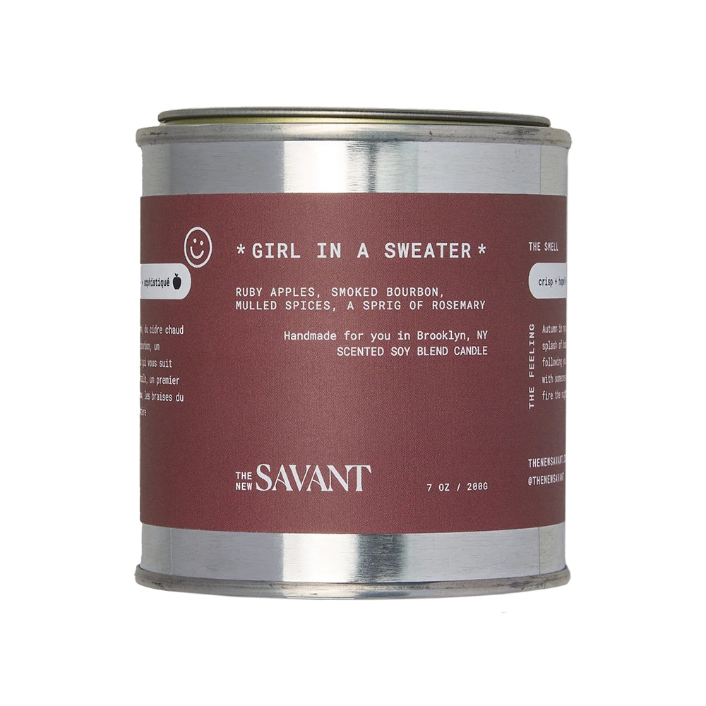 Candle canister labeled 'Girl in a Sweater' by The Savant on a white background