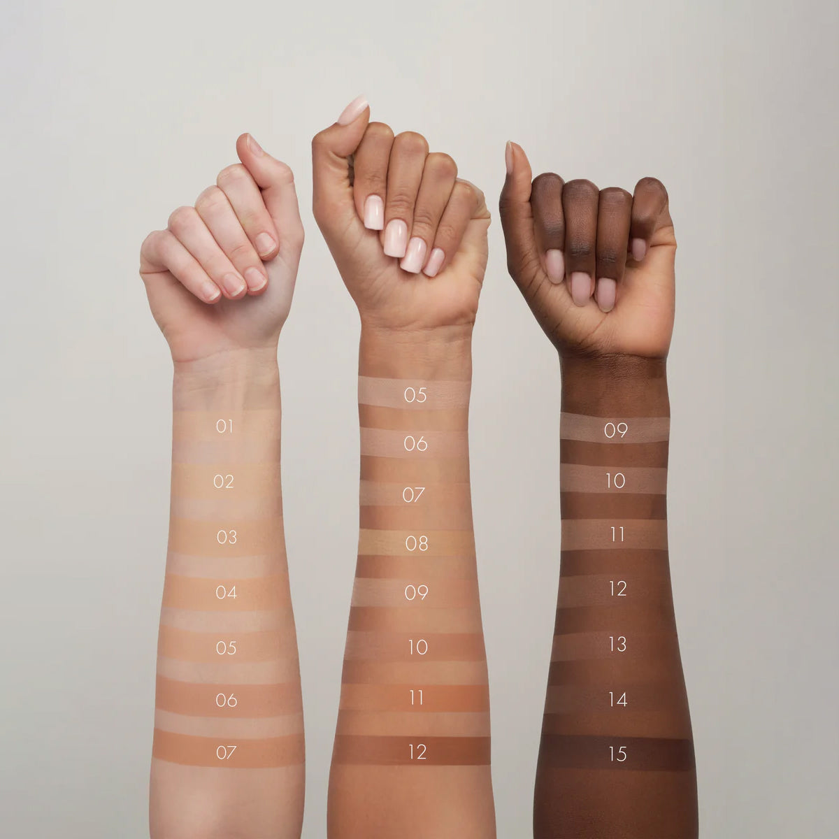 Three hands with swatches of different skin tones on a neutral background