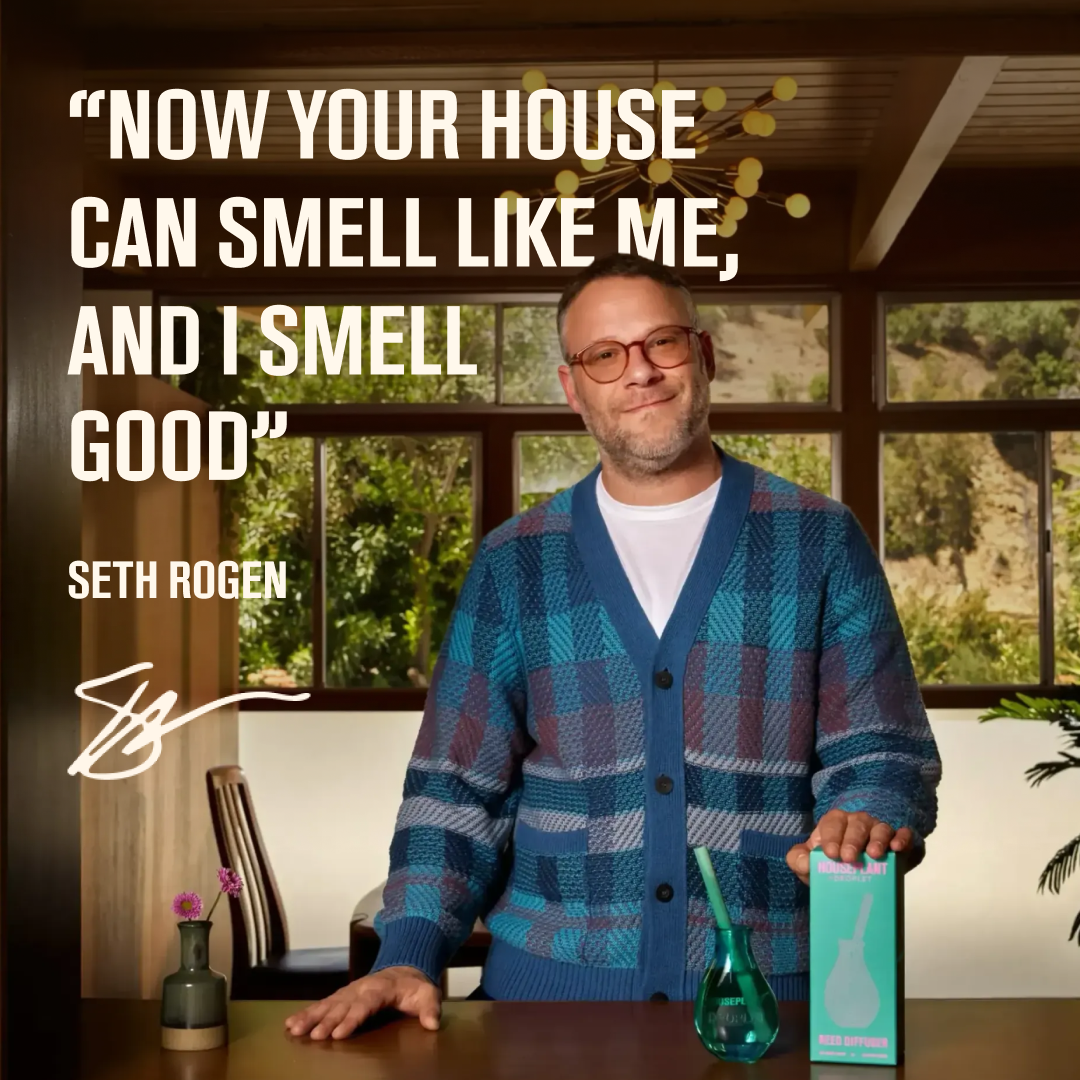 Seth Rogen stands indoors holding a teal glass diffuser and a turquoise box labeled 'Petal & Pine' next to a small vase with pink flowers. Large text reads, 'NOW YOUR HOUSE CAN SMELL LIKE ME, AND I SMELL GOOD' with Seth Rogen's name below.