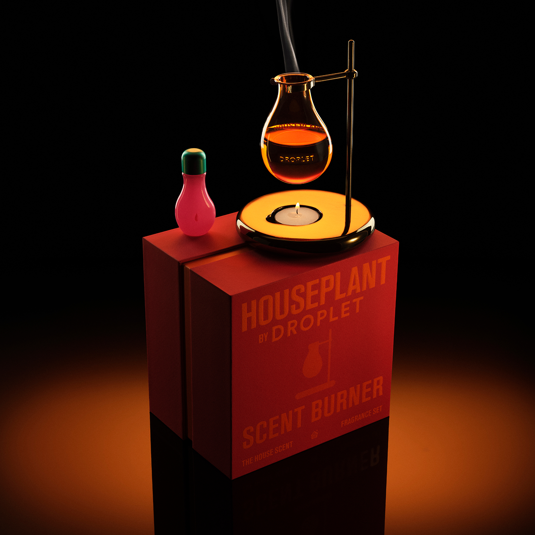 A stylized product render of a red rectangular box labeled 'HOUSEPLANT BY DROPLET SCENT BURNER' on a black background, with a pink droplet-shaped item on top and a glowing orange burner apparatus above it.