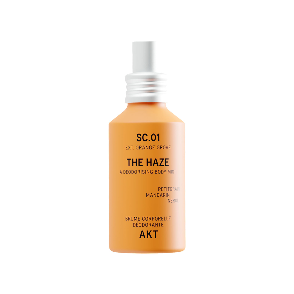 Bottle of The Haze SC.01 Orange Grove deodorant spray, featuring an orange body and a white spray nozzle, centered on a plain white background.