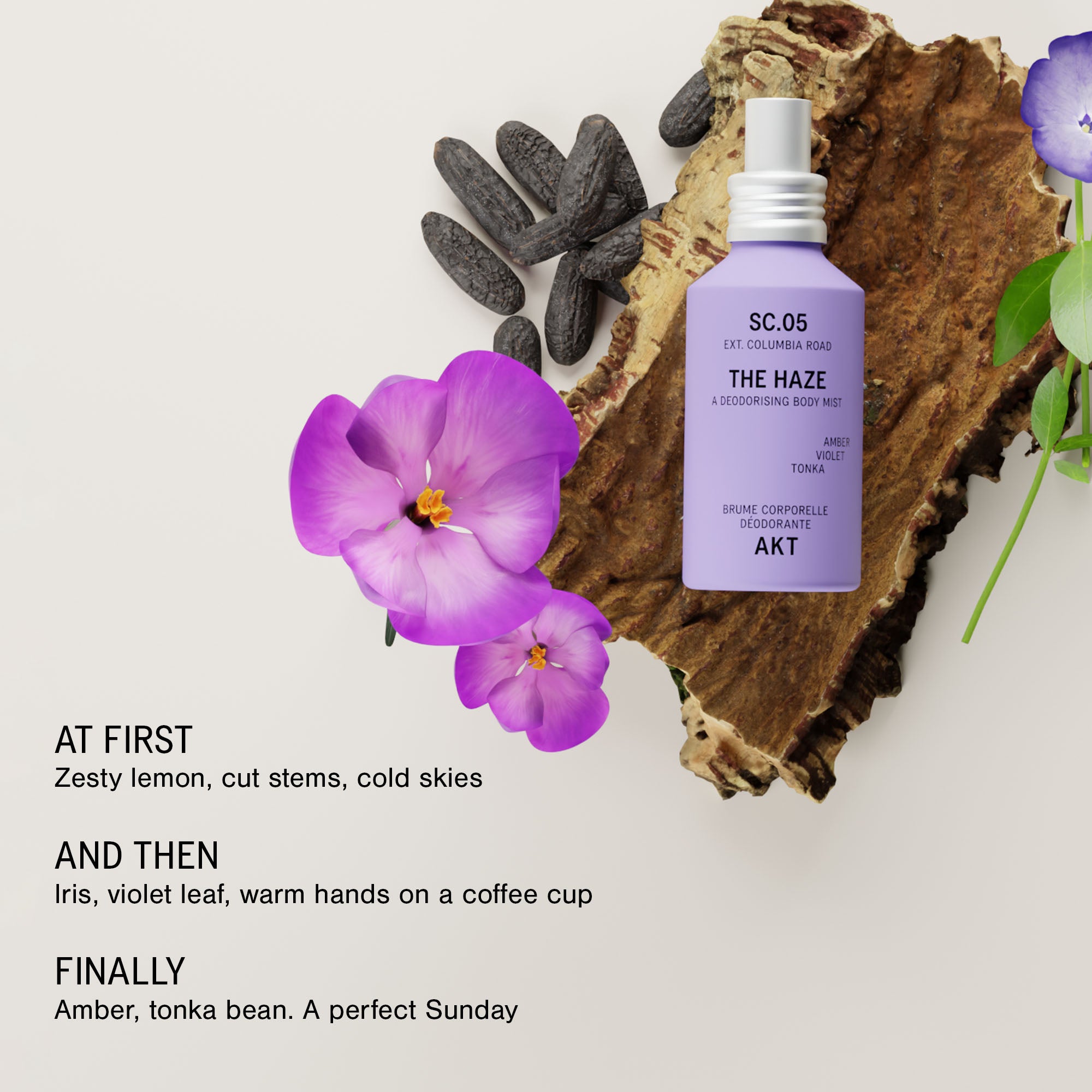 Bottle of AKT The Haze SC. 05 Columbia Road, styled on a wood slice with purple flowers and dark stones against a light beige background with text describing scent notes.