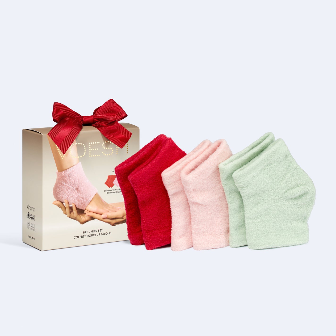 Set of red, pink, and green socks with a gift box on a light gray background