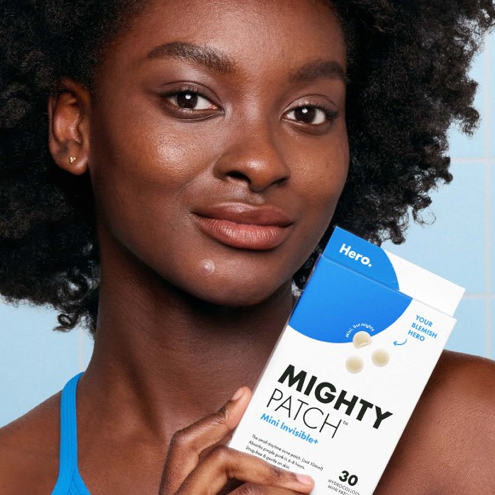 Woman holding 'Mighty Patch' product package with a blue and white design.