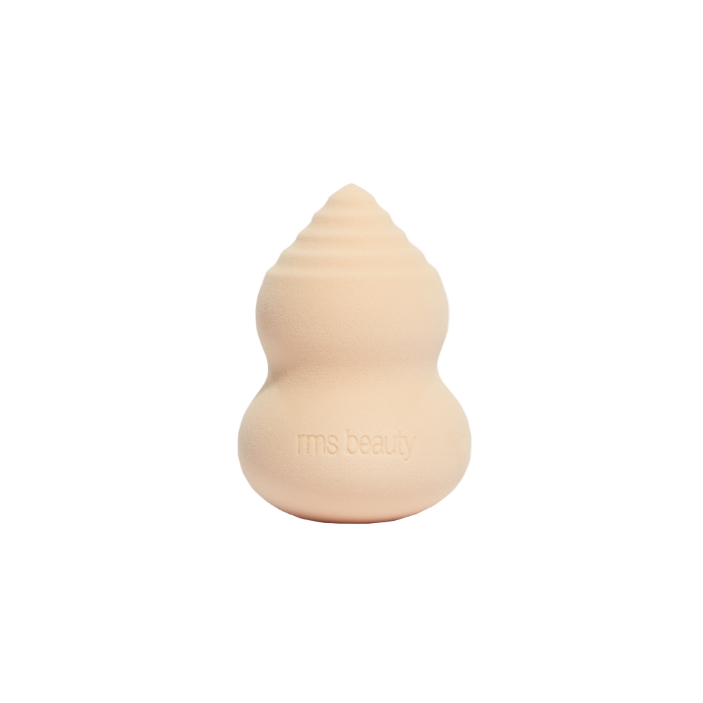 Beige makeup sponge with 'rms beauty' branding on a white background
