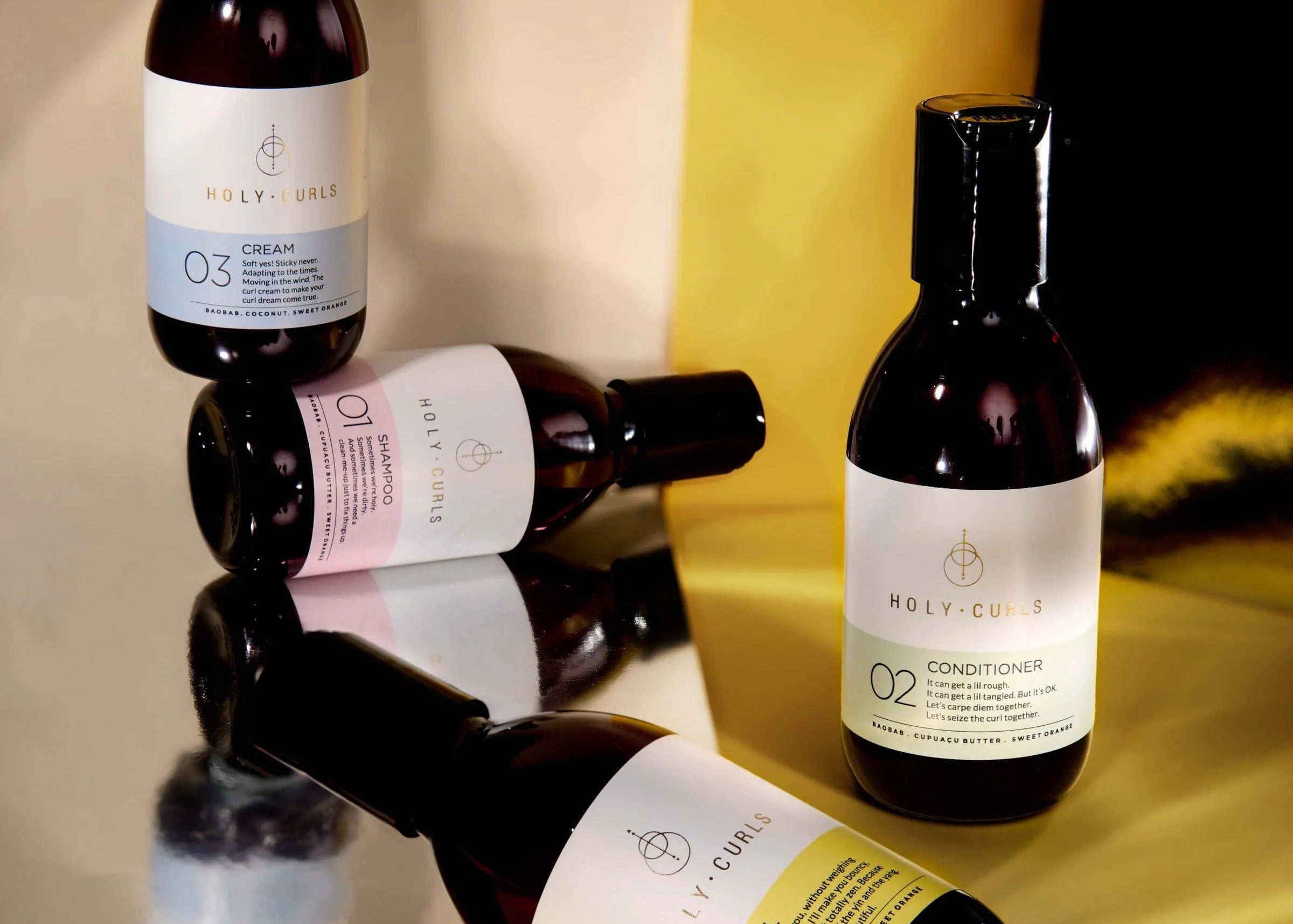 Set of hair care products with visible labels on a reflective surface.