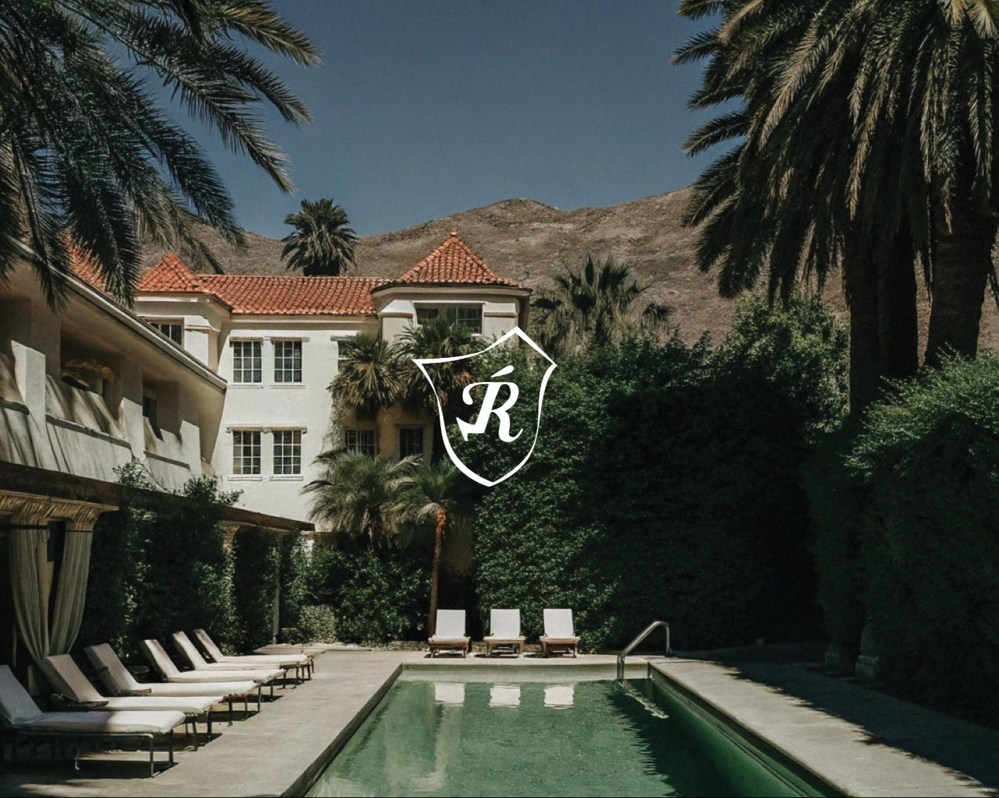 Luxury villa with pool and palm trees, featuring a logo in the center.
