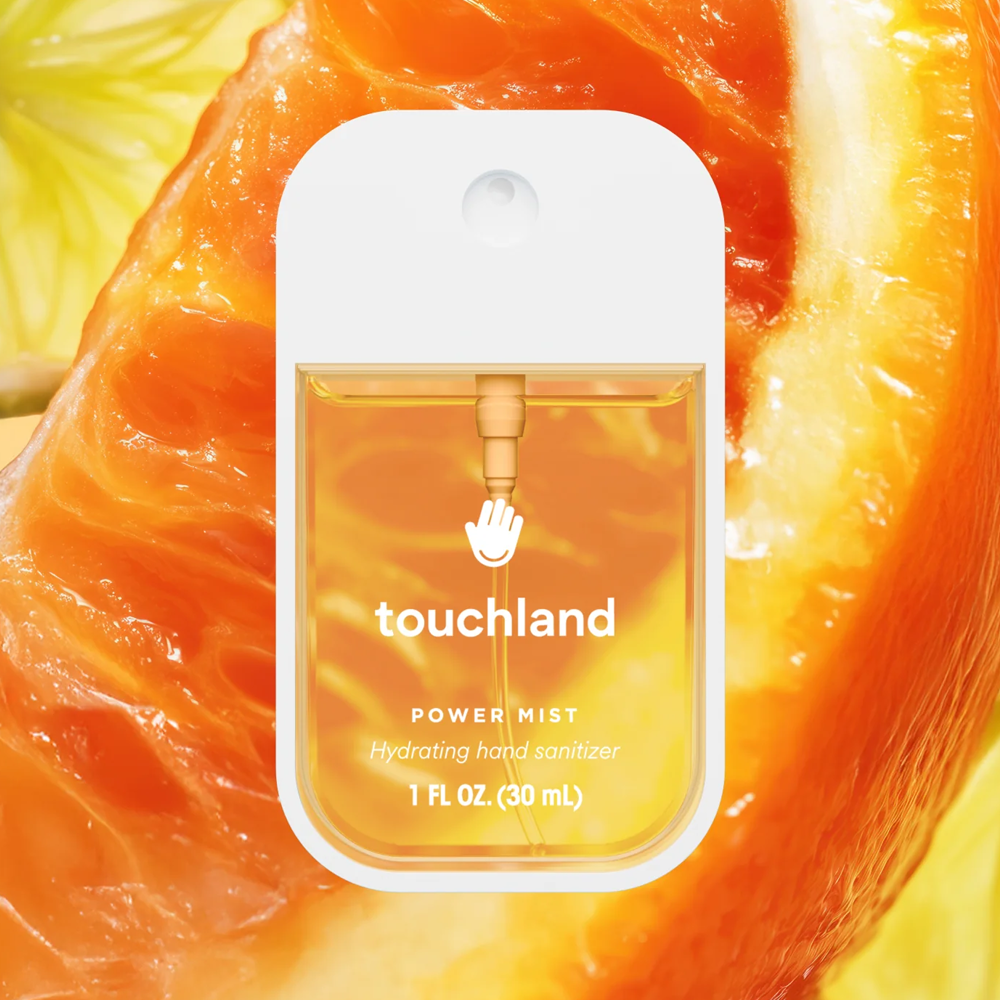 Touchland power mist packaging on a close-up of an orange slice