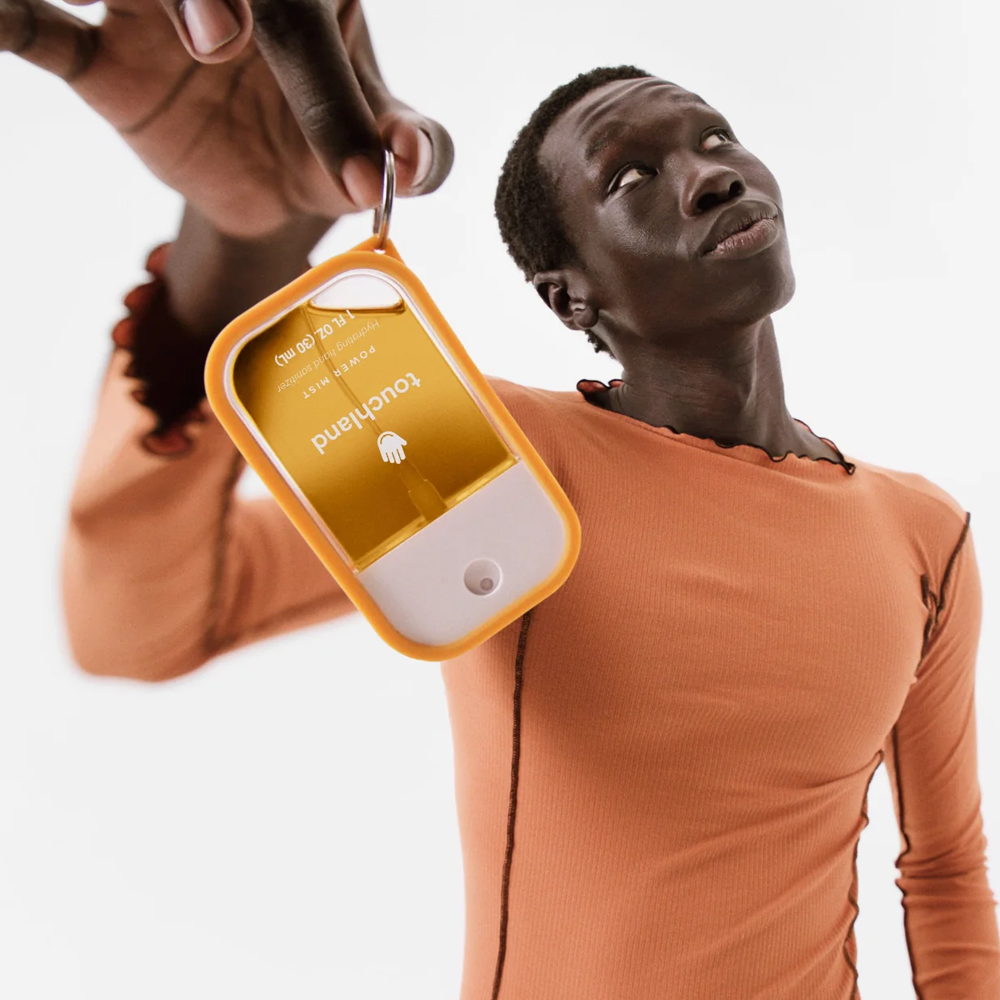 Person holding Touchland product on a white background