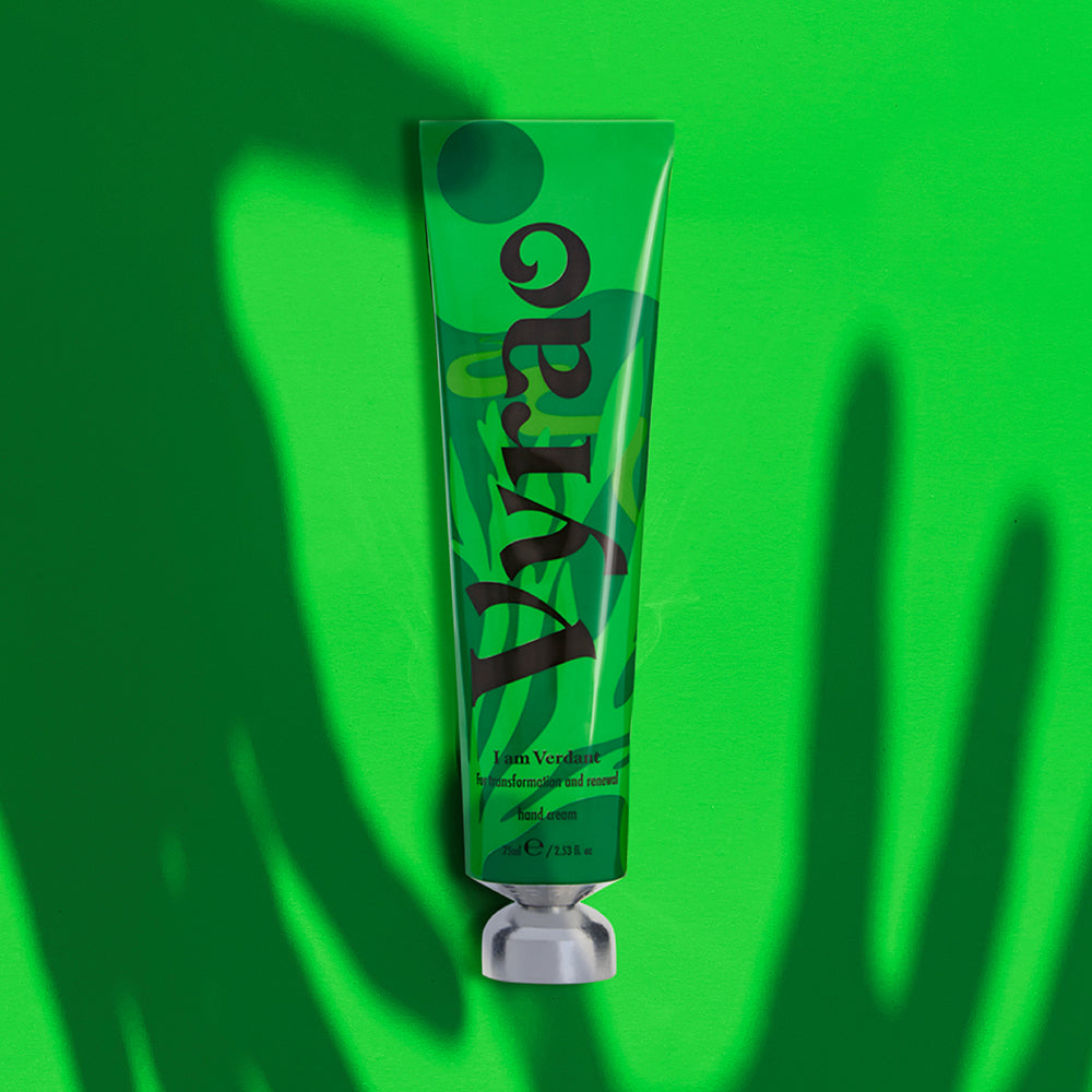 Green hand cream on a green background with shadow of hands