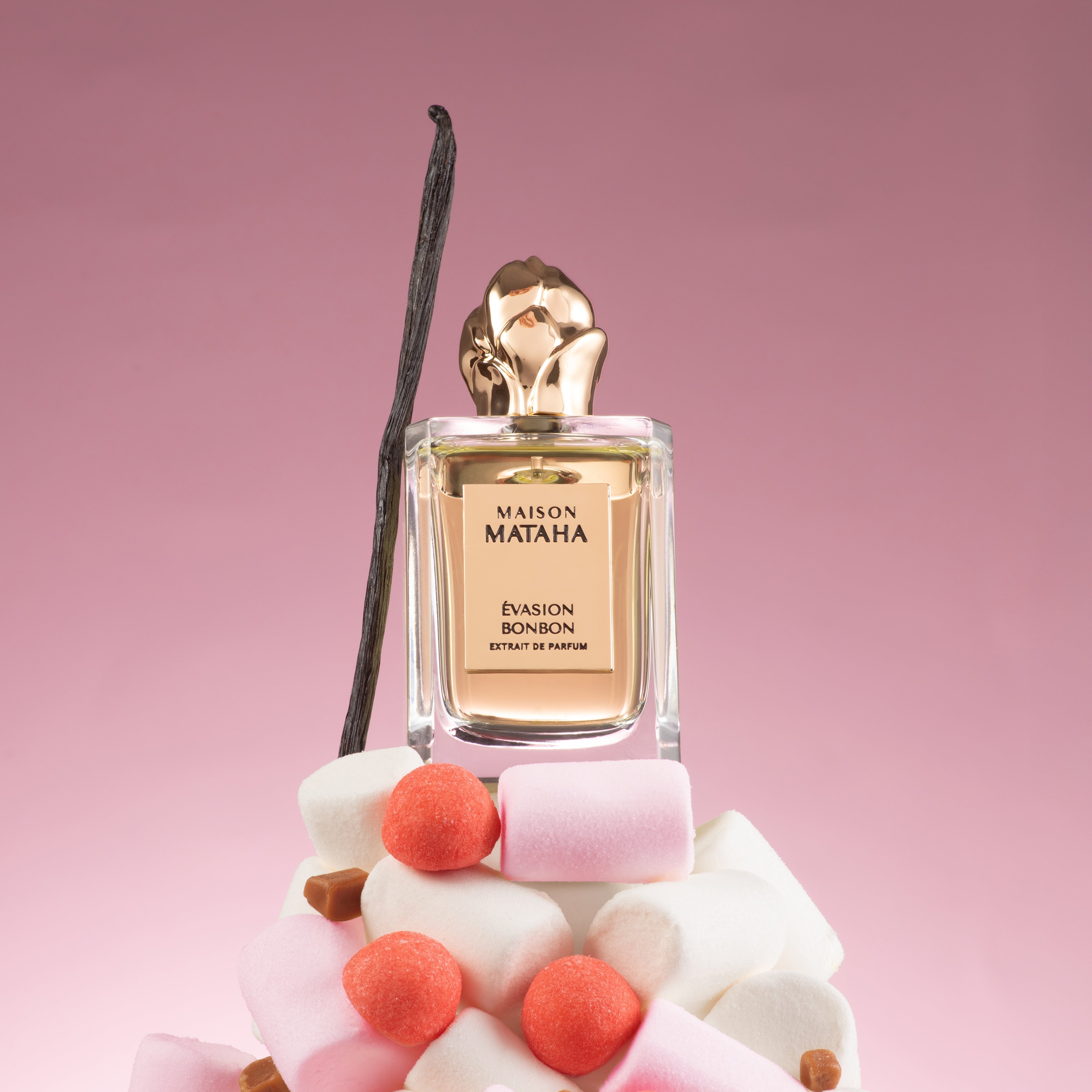 Perfume bottle on a pile of marshmallows on a pink background