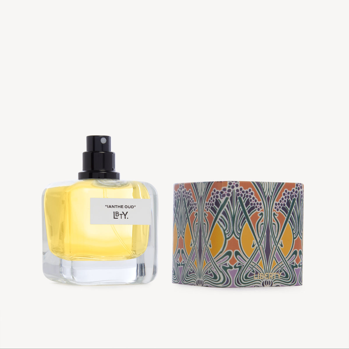Perfume bottle with yellow liquid and decorative packaging on a white background