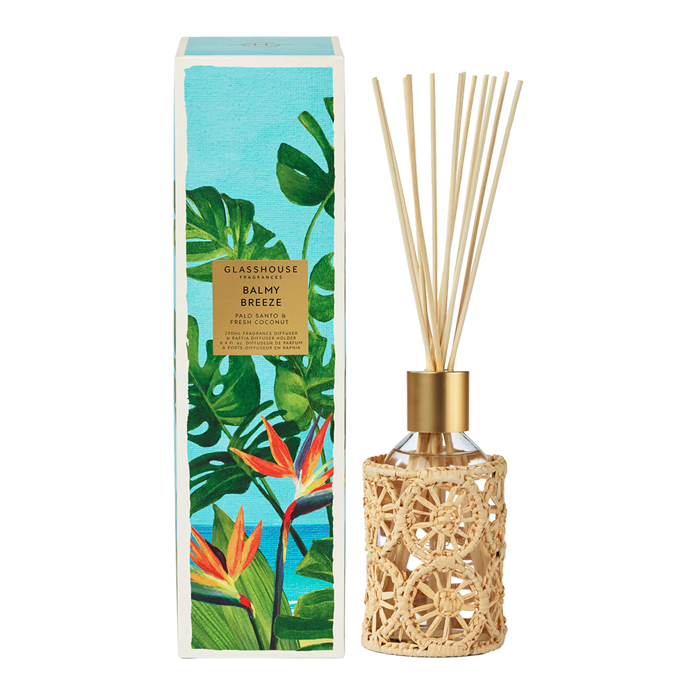 Reed diffuser with decorative packaging featuring tropical leaves on a white background