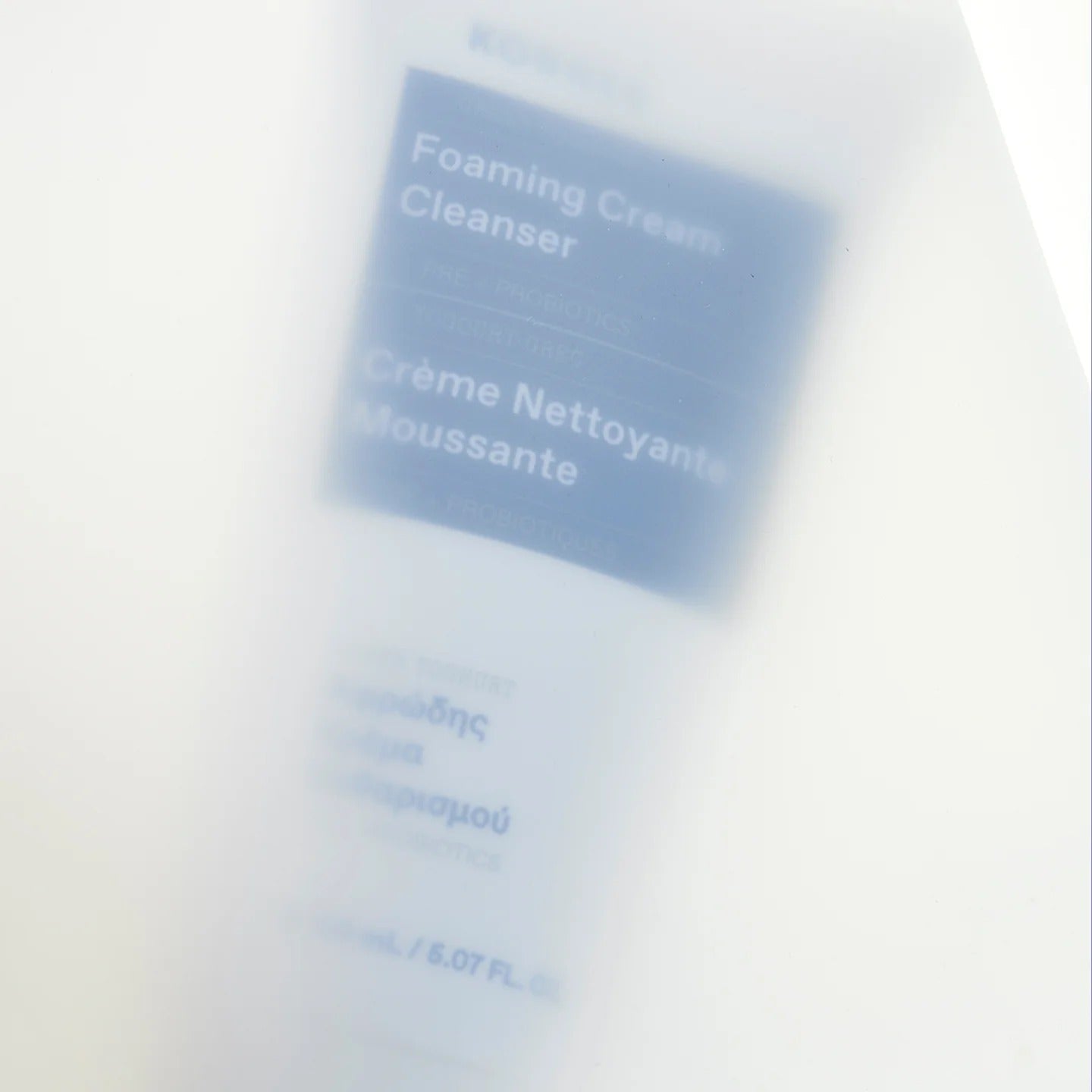 Foaming Cream Cleanser packaging with text on a blurred background