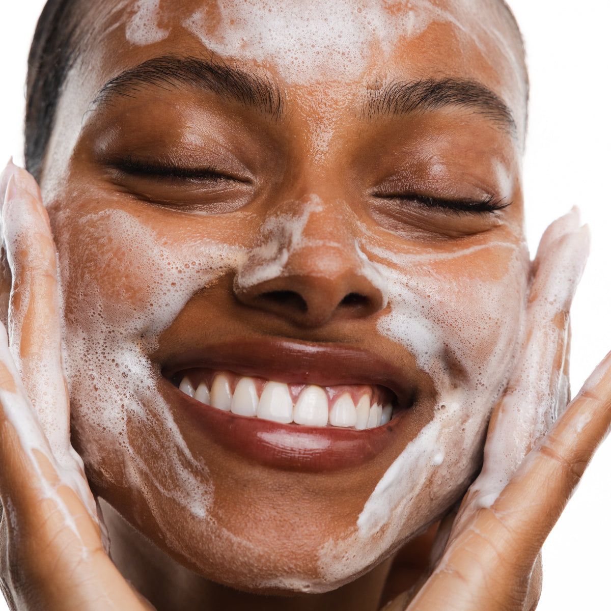 Woman applying a facial mask with a close-up of her face.