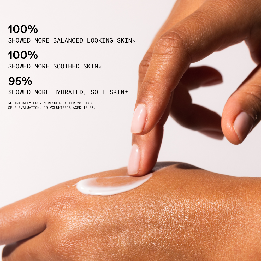 Hand applying cream to skin with text on a white background