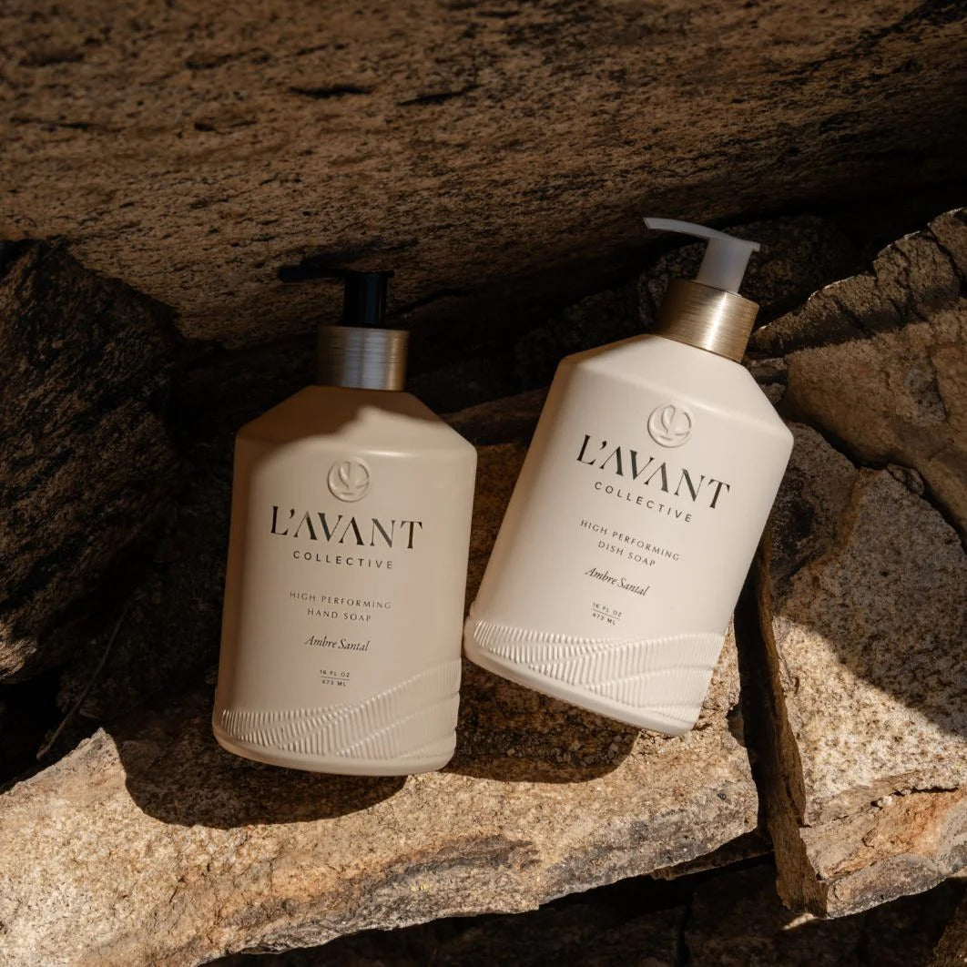 Two bottles of L'Avant Collective on a stone surface