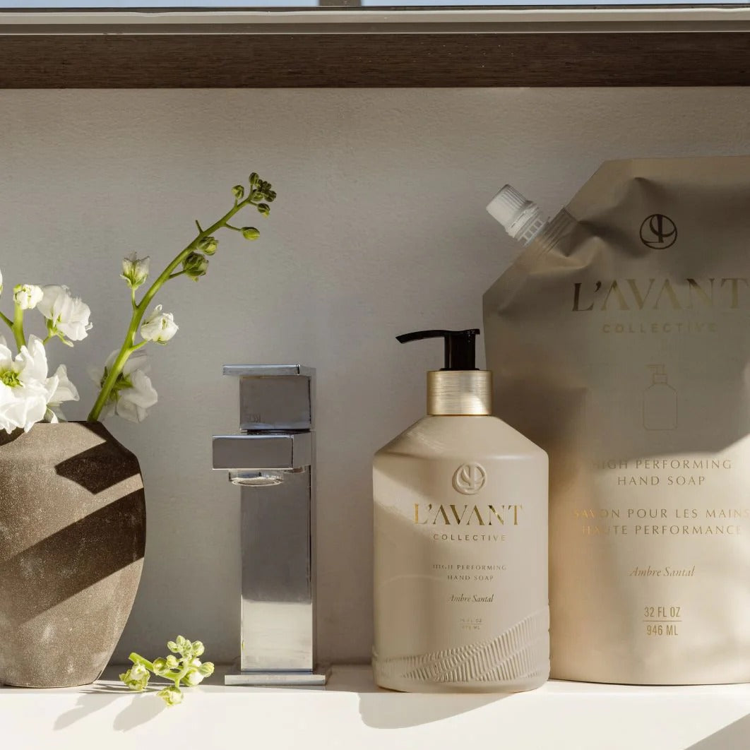 Bathroom setting with L'AVANT products, including a bottle and a bag, on a counter.