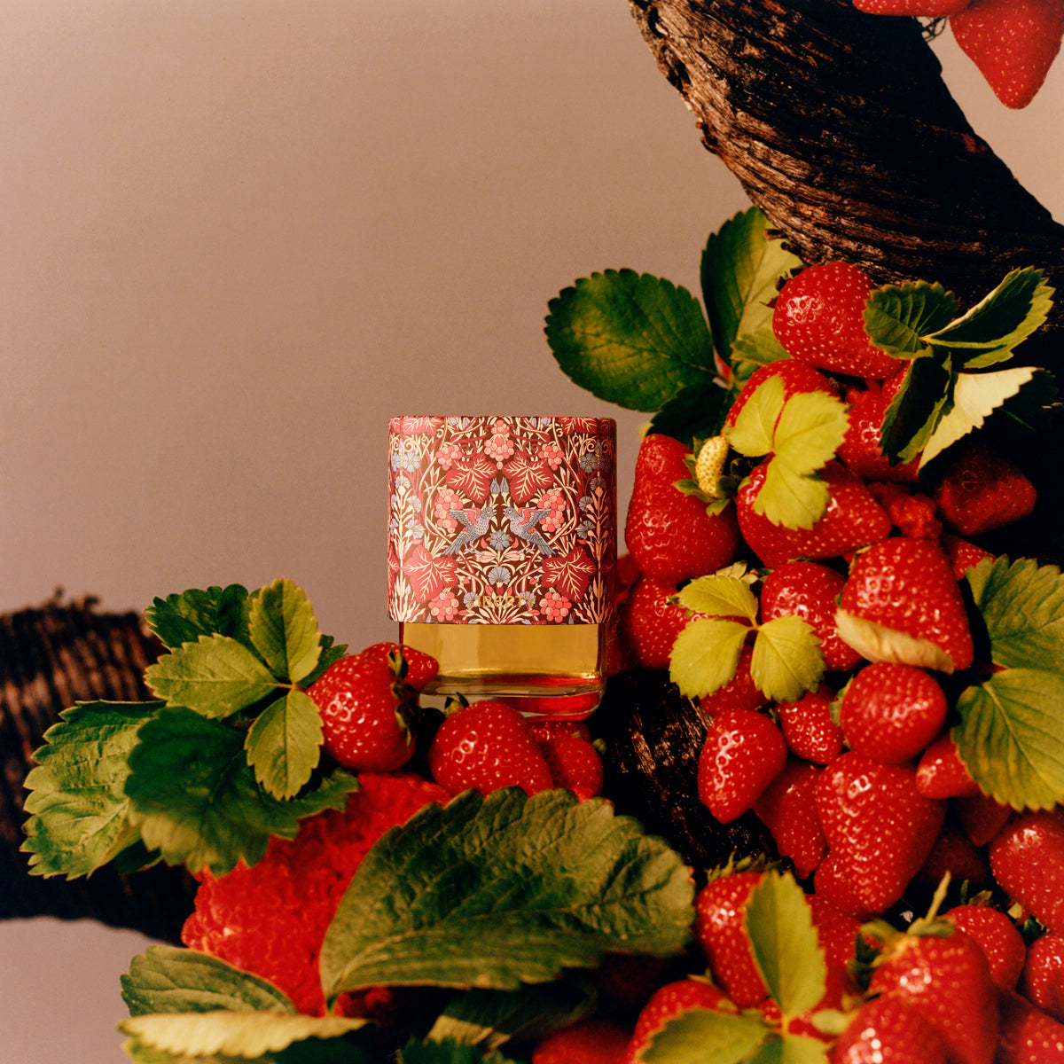 Floral-patterned fragrance surrounded by strawberries with a blurred background