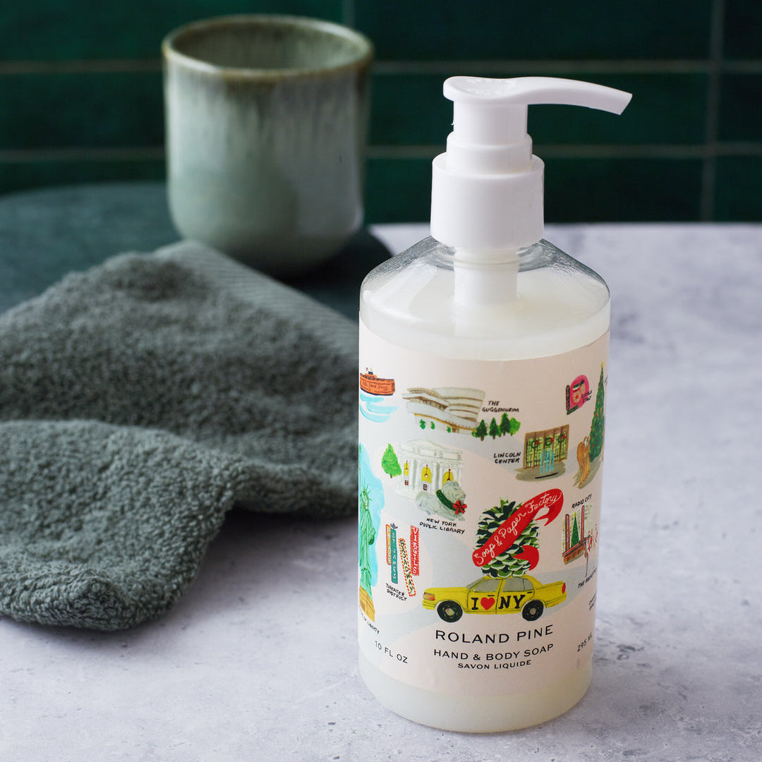Roland Pine Hand soap bottle with pump on a gray surface with a green towel and container in the background.