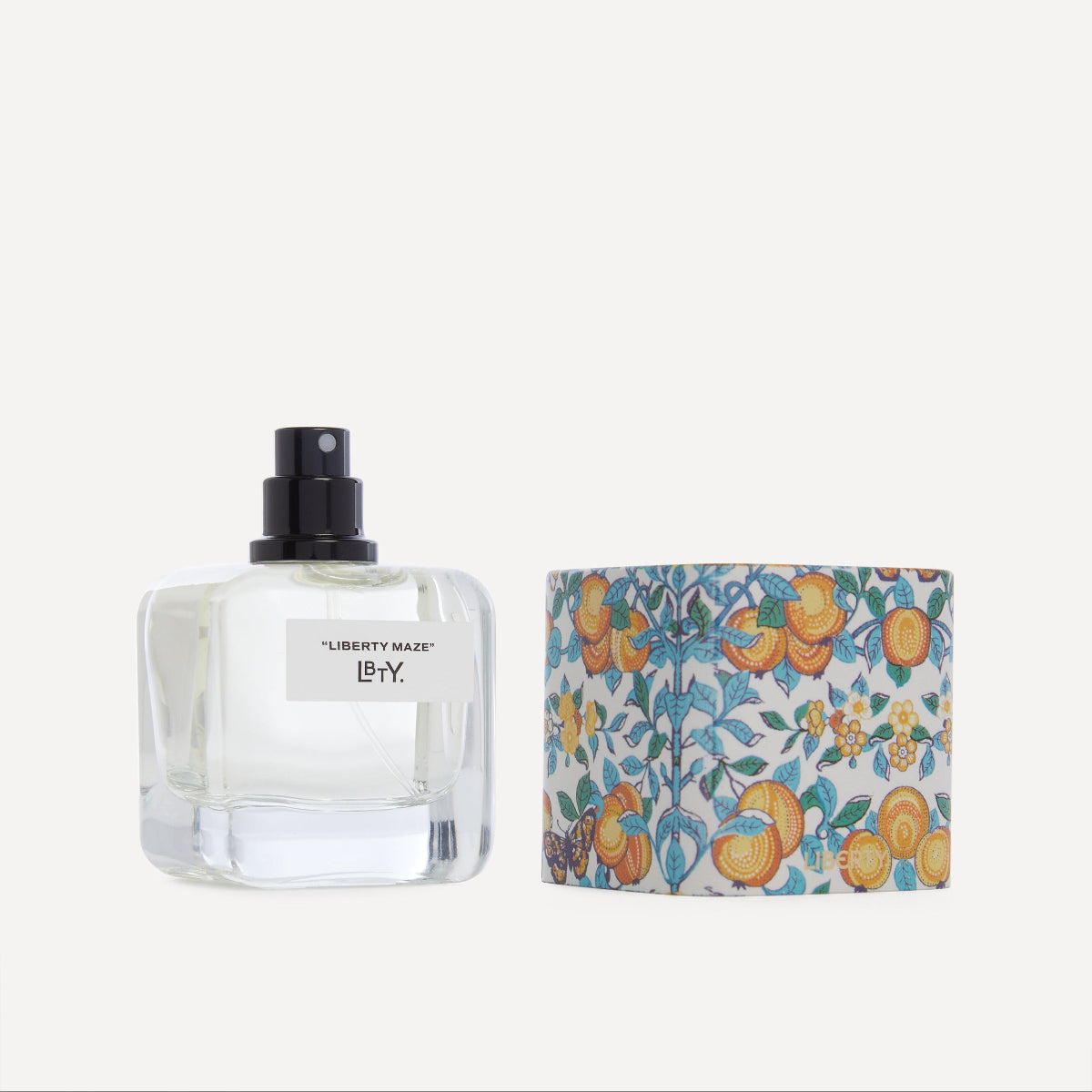 Perfume bottle and its packaging with floral design on a white background