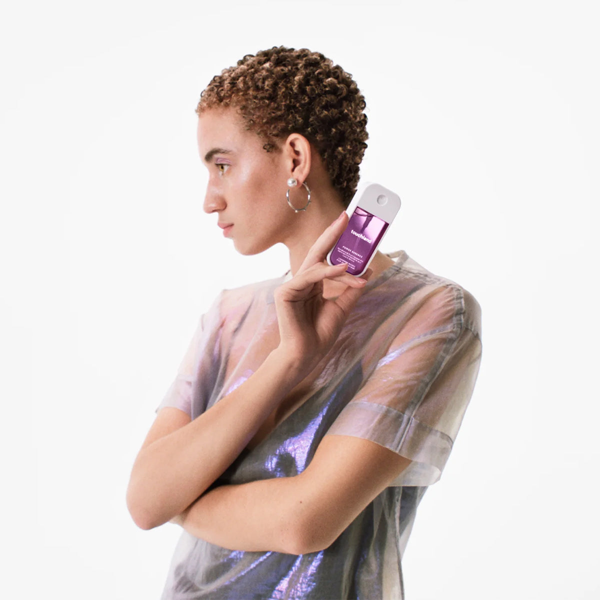 Person holding Touchland Power Essence Hydrating Body & Hair Mist - Cashmere Woods against a white background
