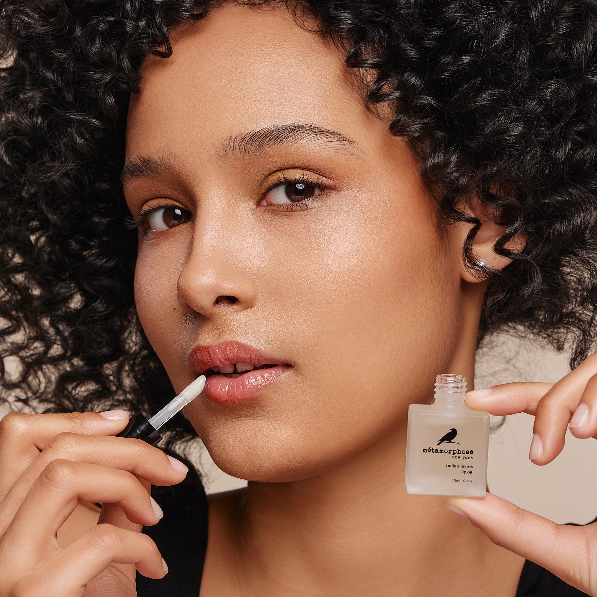 Woman applying Metamorphose's Lip Oil.