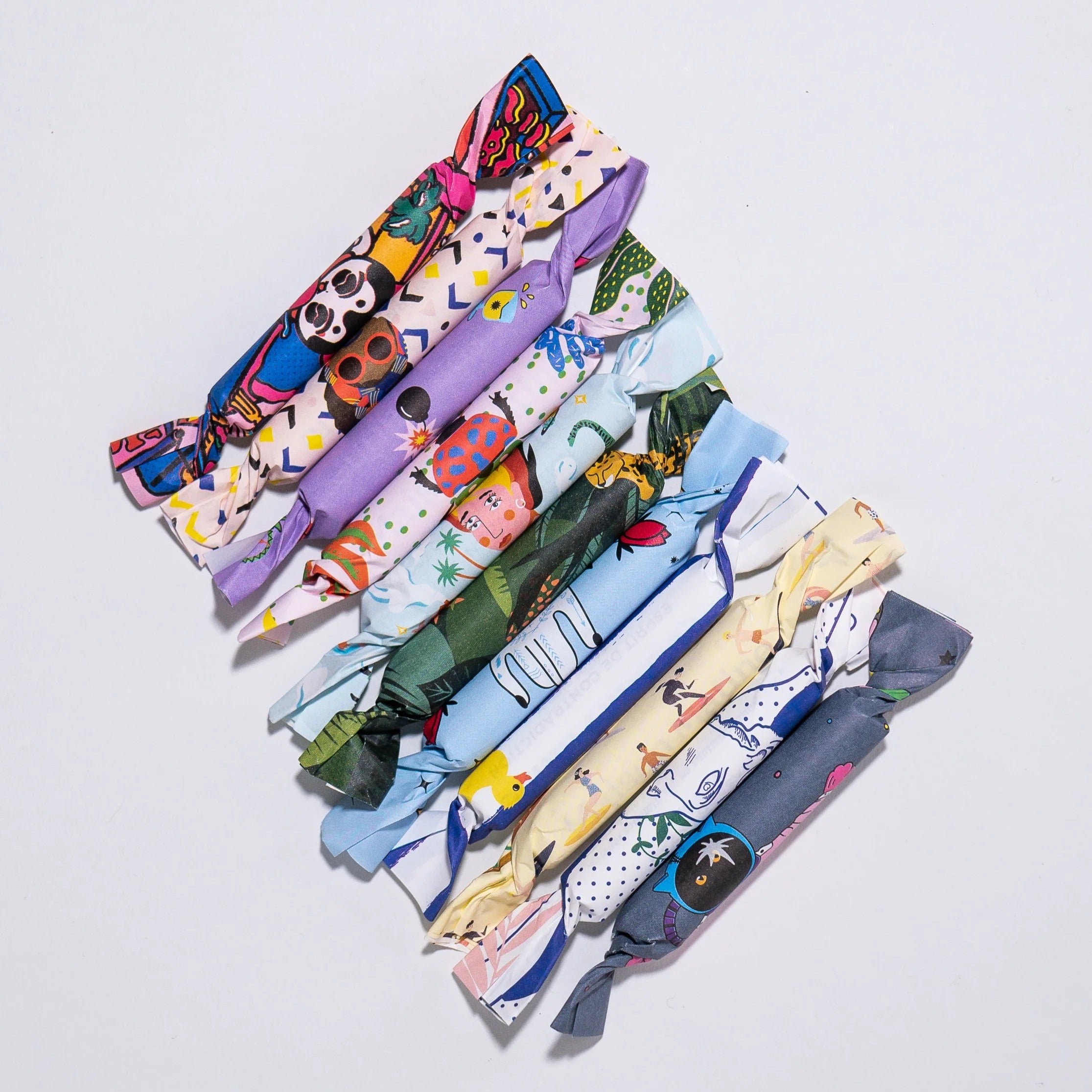 Maison Matine Perfume Minis wrapped in colorful papers on a light gray background