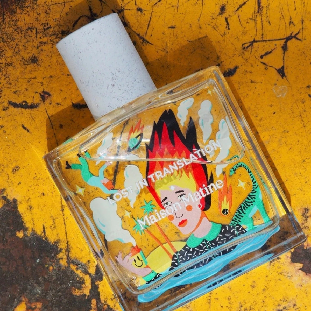 Small bottle with colorful label on a yellow textured surface