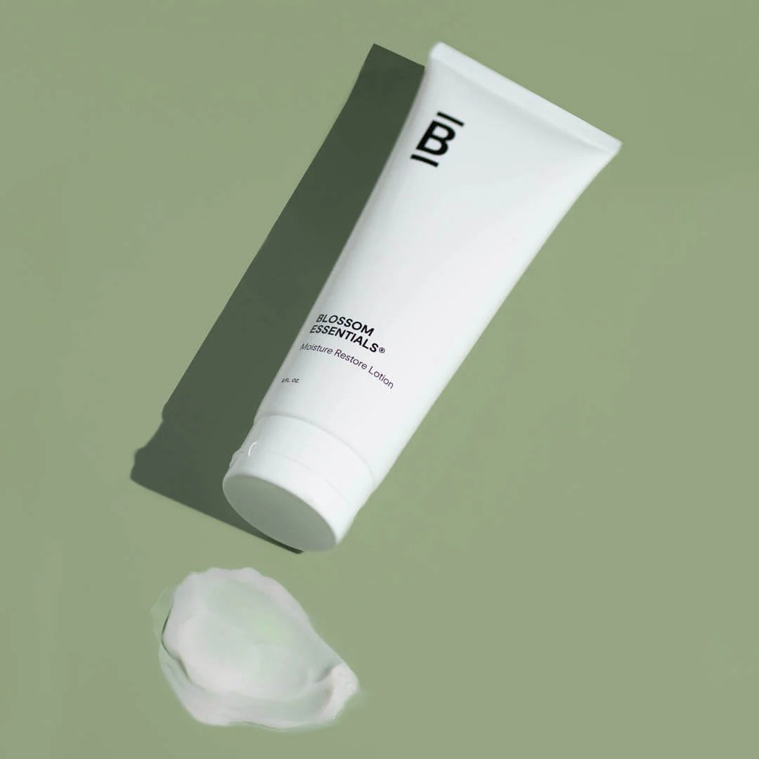 White tube of Blossom Essentials lotion on a green background