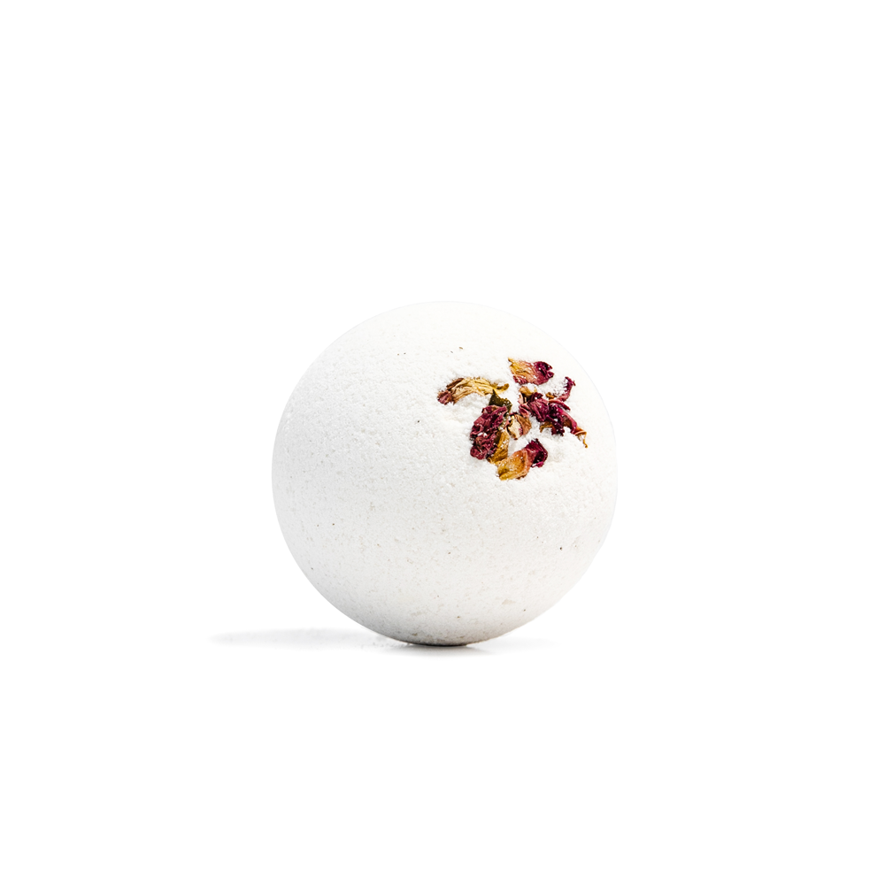 A white textured bath bomb sphere with dried rose petals pressed into the top, photographed on a seamless white background.