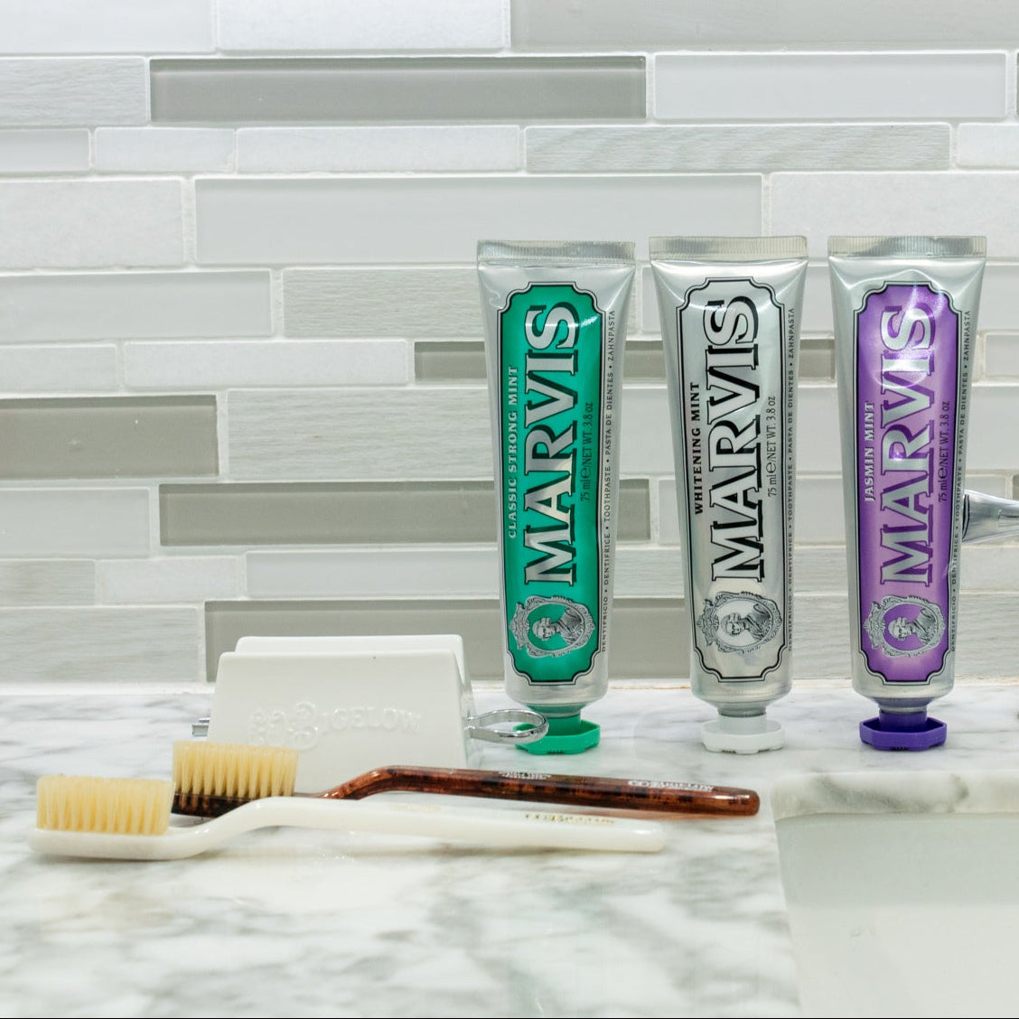Marvis toothpaste tubes on a bathroom counter with a tiled wall background