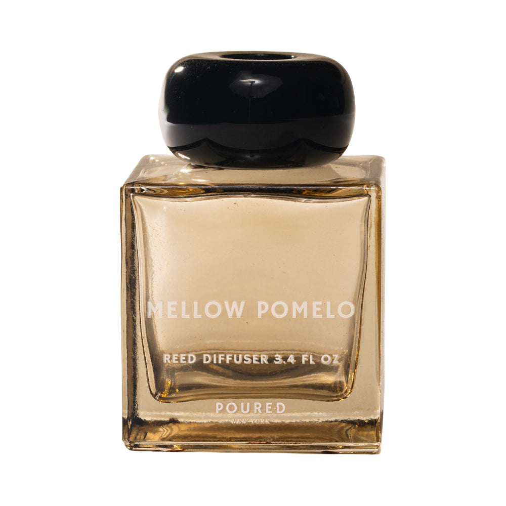 Reed diffuser bottle labeled 'Mellow Pomelo' on a white background