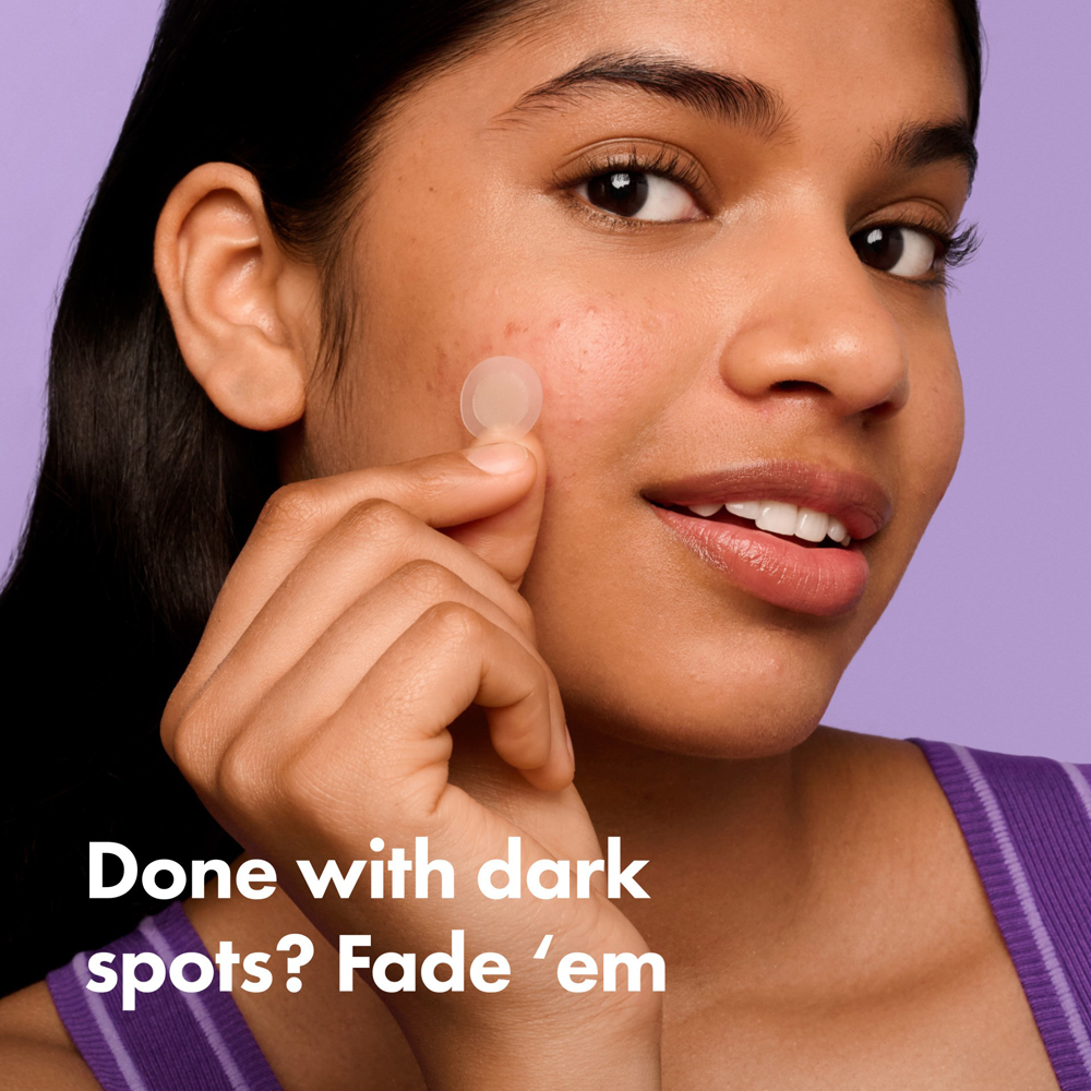 Woman applying a product to her face with a purple background