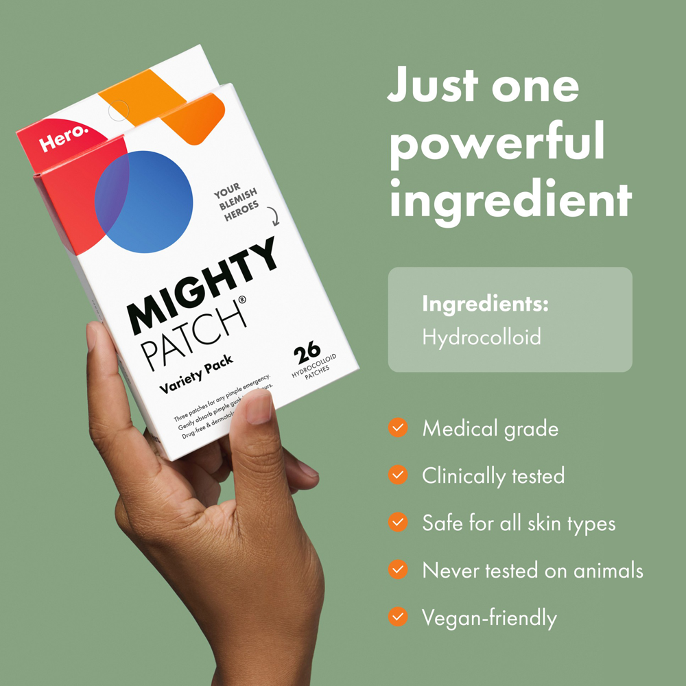 Hand holding a Mighty Patch variety pack with product details on a green background