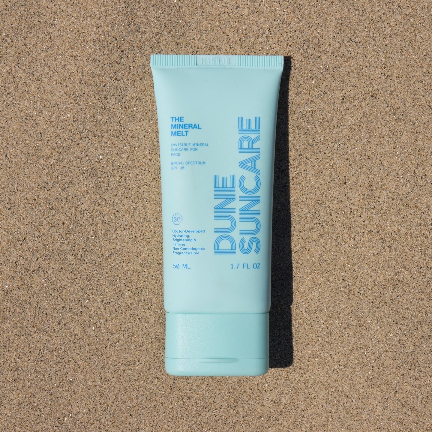 Tube of Dune Suncare sunscreen on sand