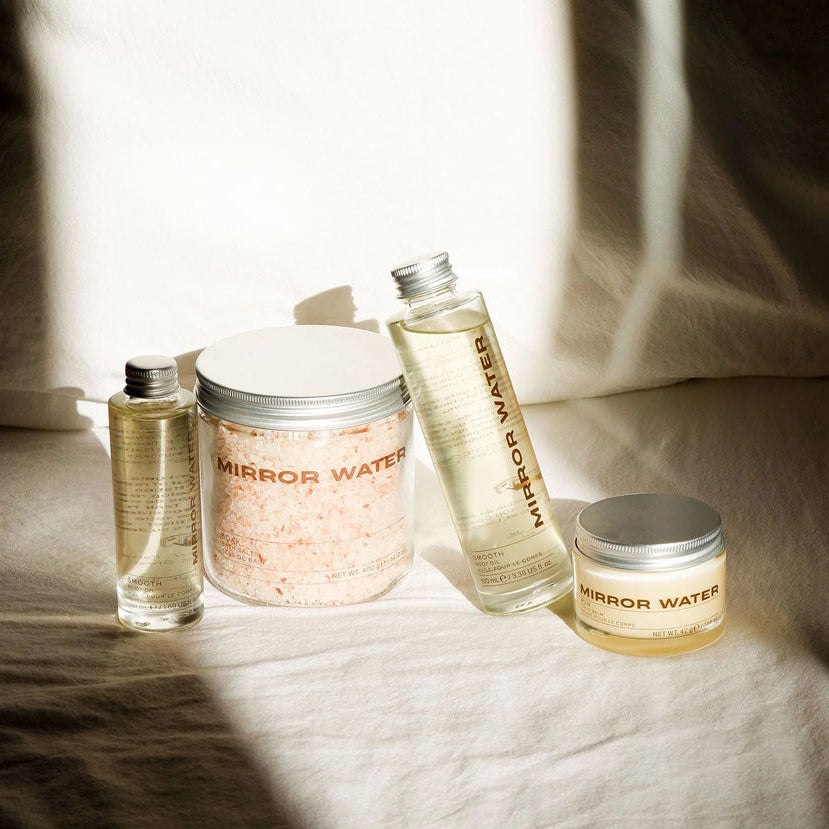 Mirror Water skincare products on a textured surface with soft lighting