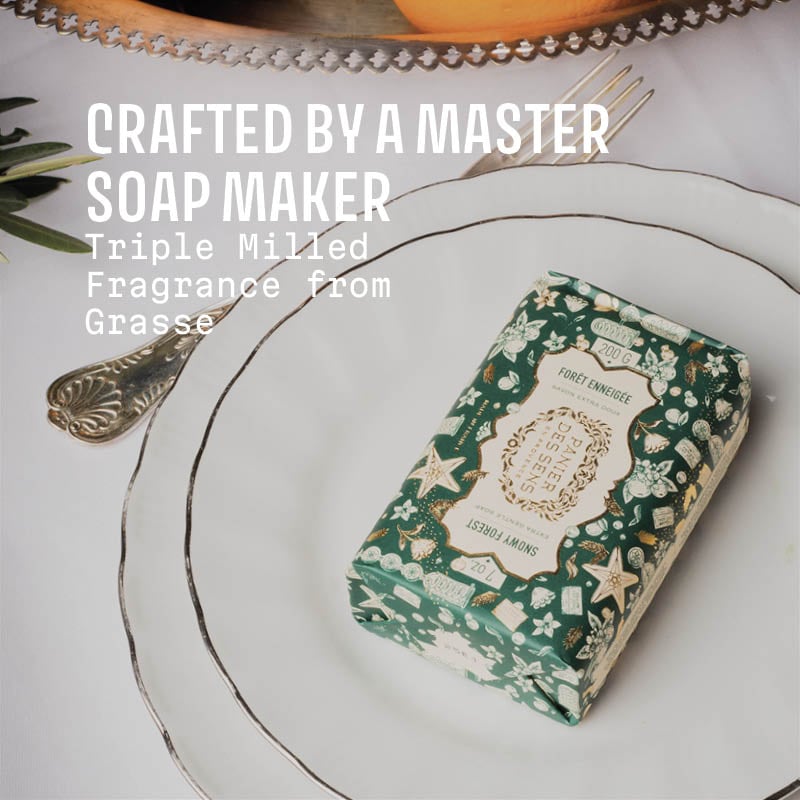 Decorative soap bar with floral design on a white plate, text 'Crafted by a Master Soap Maker' displayed.