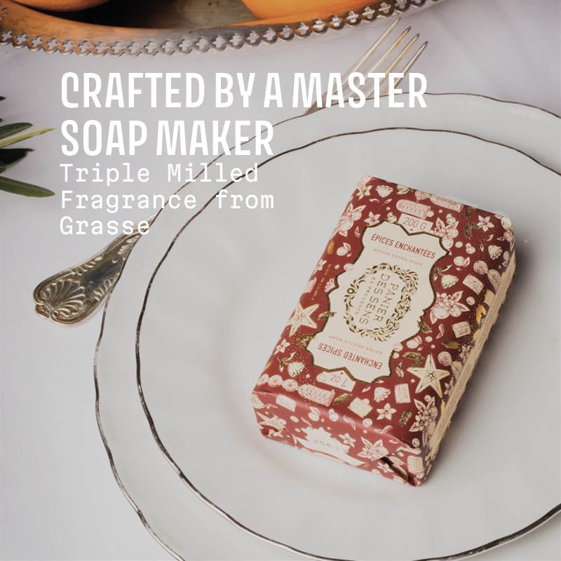 Decorative soap bar with floral design on a white plate, text 'Crafted by a Master Soap Maker' and 'Triple Milled Fragrance from Grasse'.