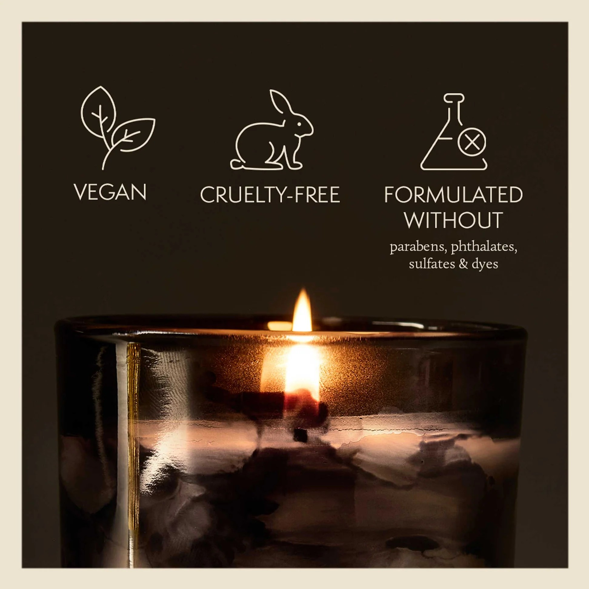 Candle with vegan, cruelty-free, and sulfate-free icons on a dark background