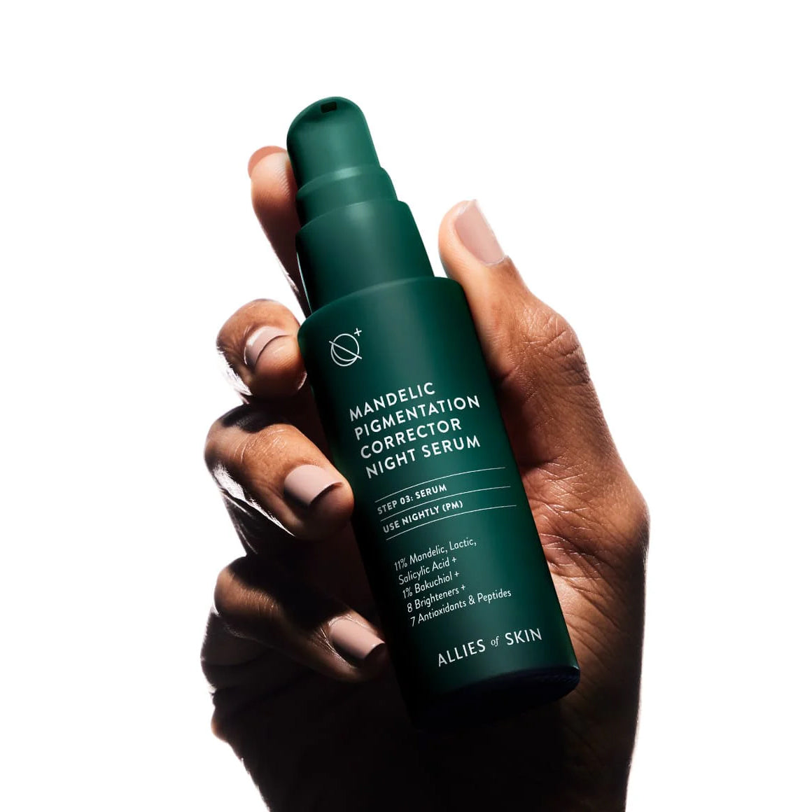 Hand holding a green skincare serum bottle labeled 'Mandelic Pigmentation Corrector Night Serum' by Allies of Skin on a white background.