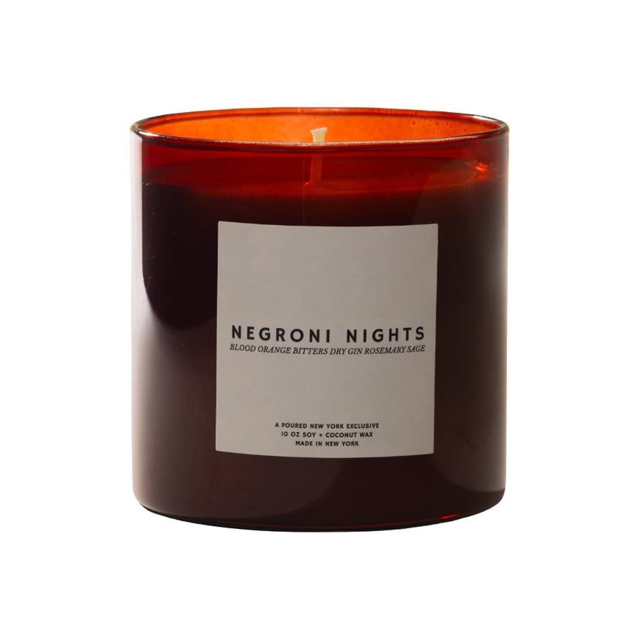 Candle with a red interior and 'Negroni Nights' label on a white background