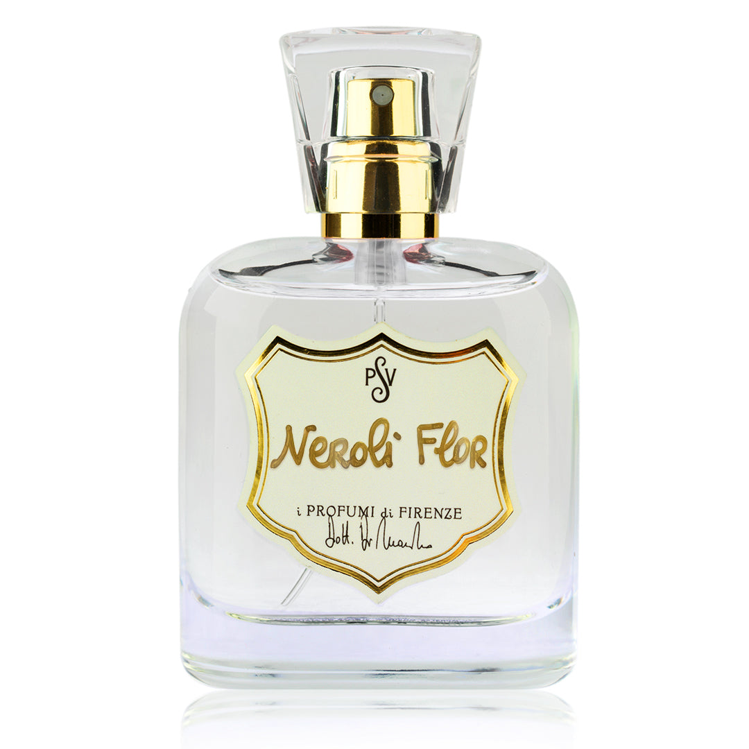 A clear glass perfume bottle with a gold spray pump and a cream shield-shaped label outlined in gold. The label reads 'Neroli Flor' and i Profumi di Firenze