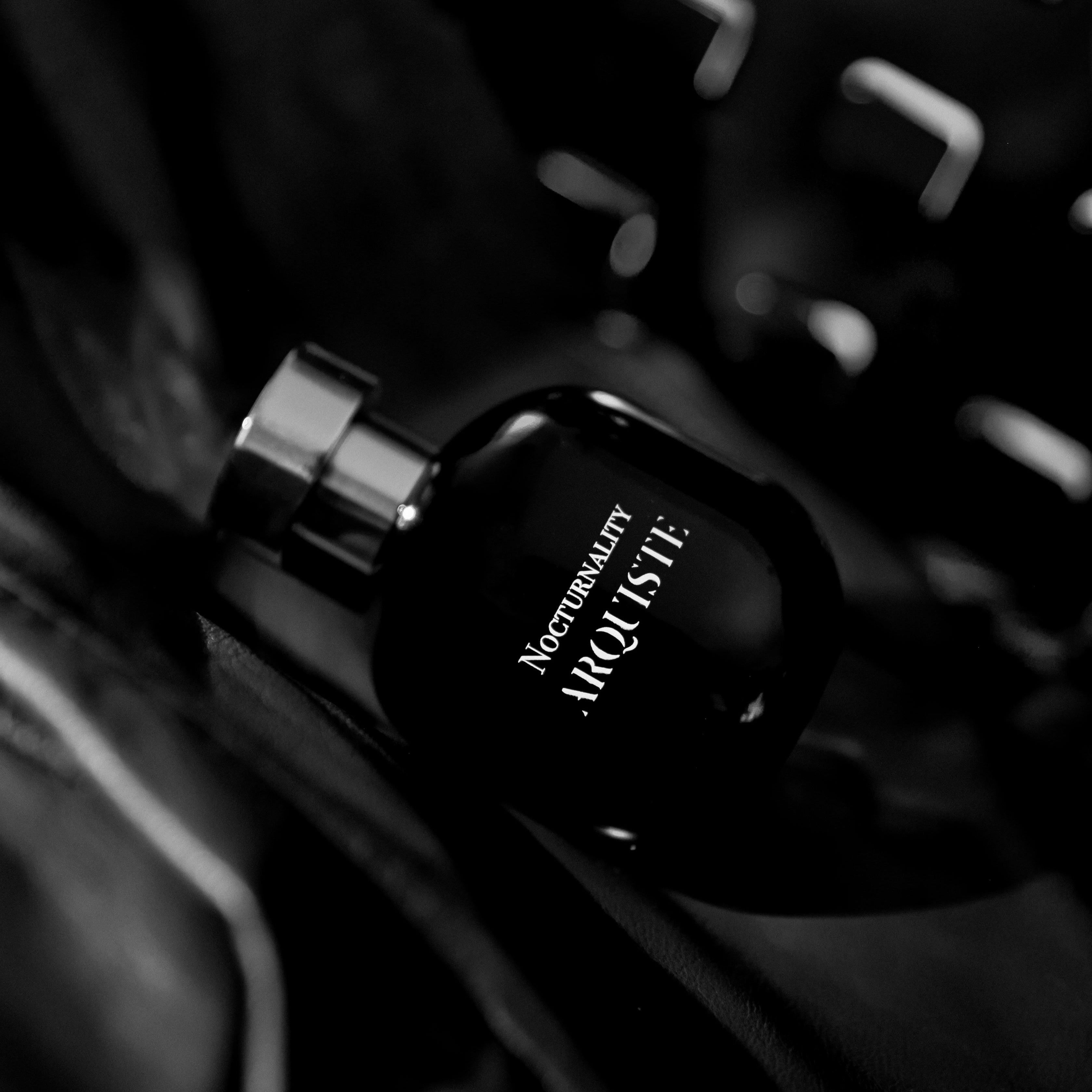 Black perfume bottle with 'Nocturnality' on a  dark background