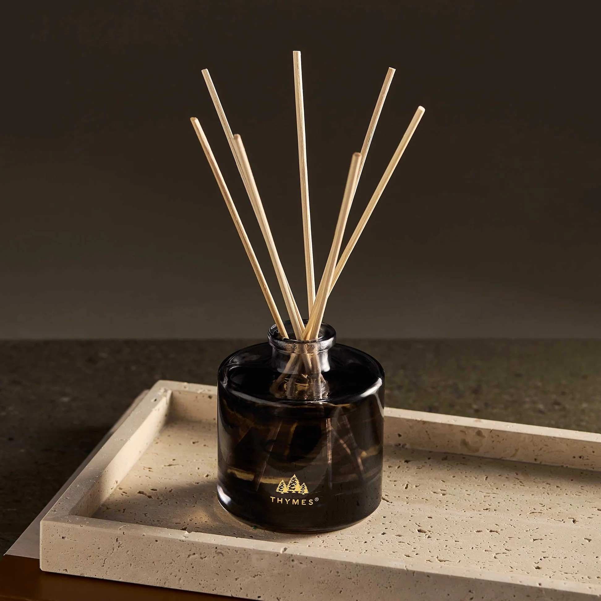 Black diffuser with wooden sticks on a stone surface